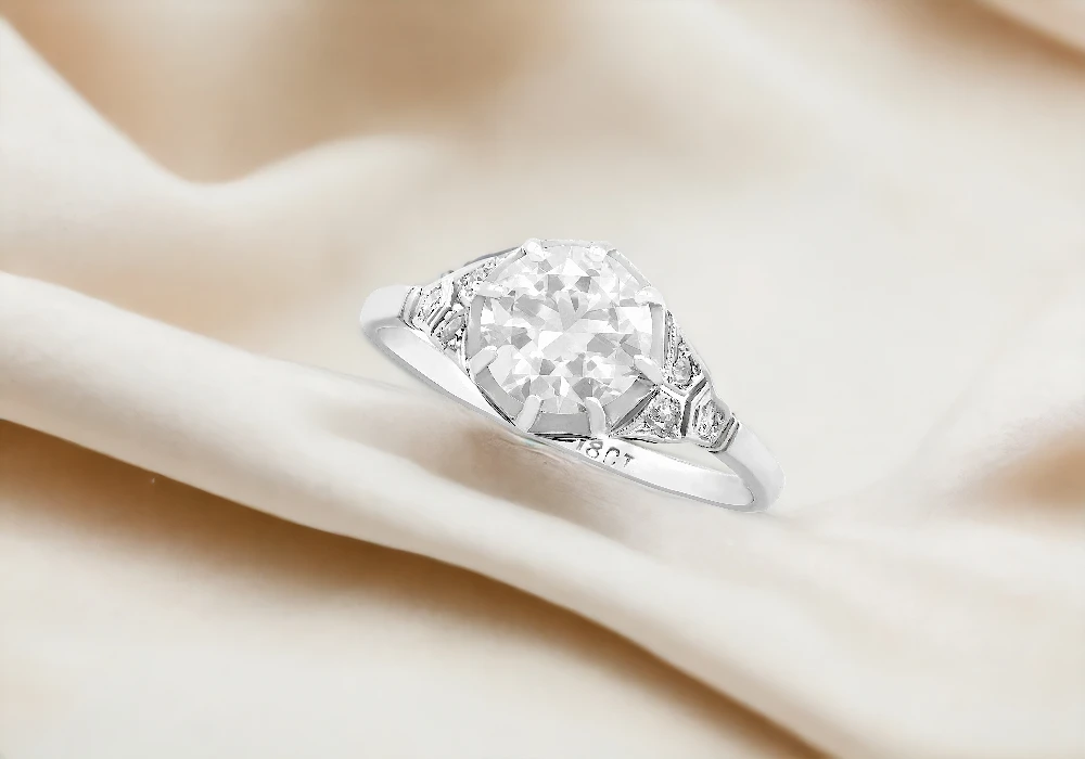 A stunning white gold ring with a dazzling diamond centerpiece, reminiscent of 1920s wedding rings.