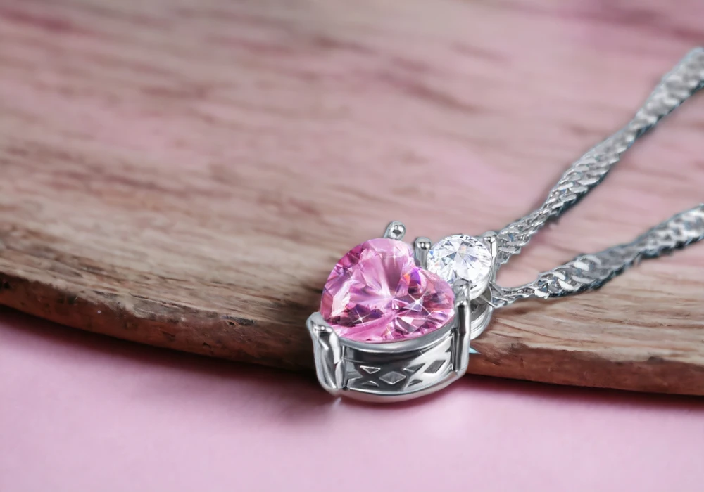 A necklace with a pink gemstone in the shape of a heart.