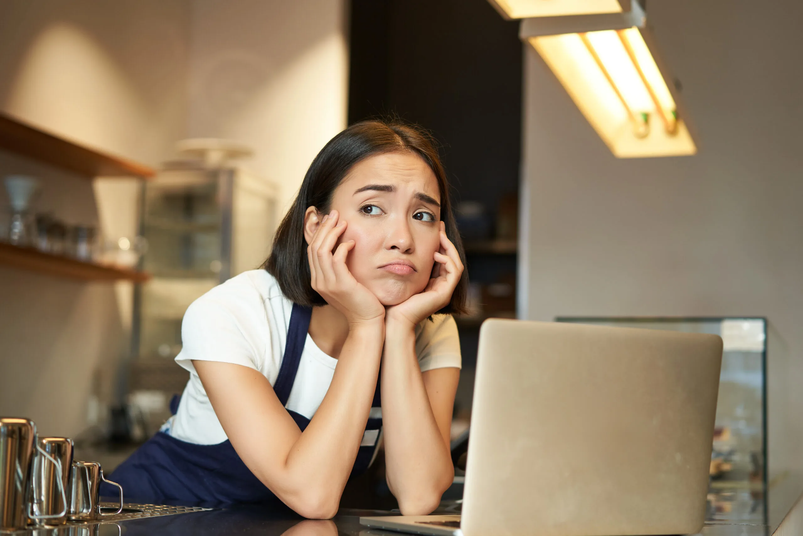 A woman sitting at a counter with a laptop.