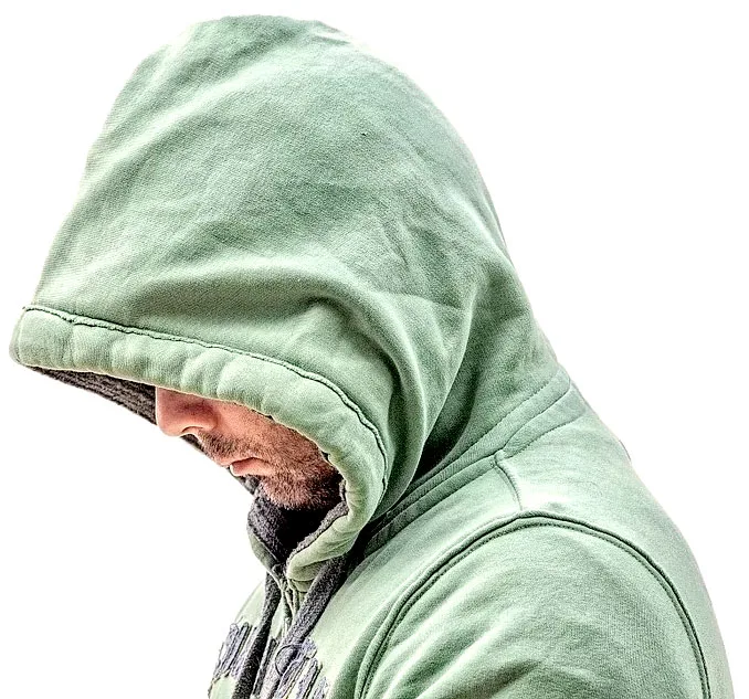 About Us 1 A man in a green hoodie looking at his phone.